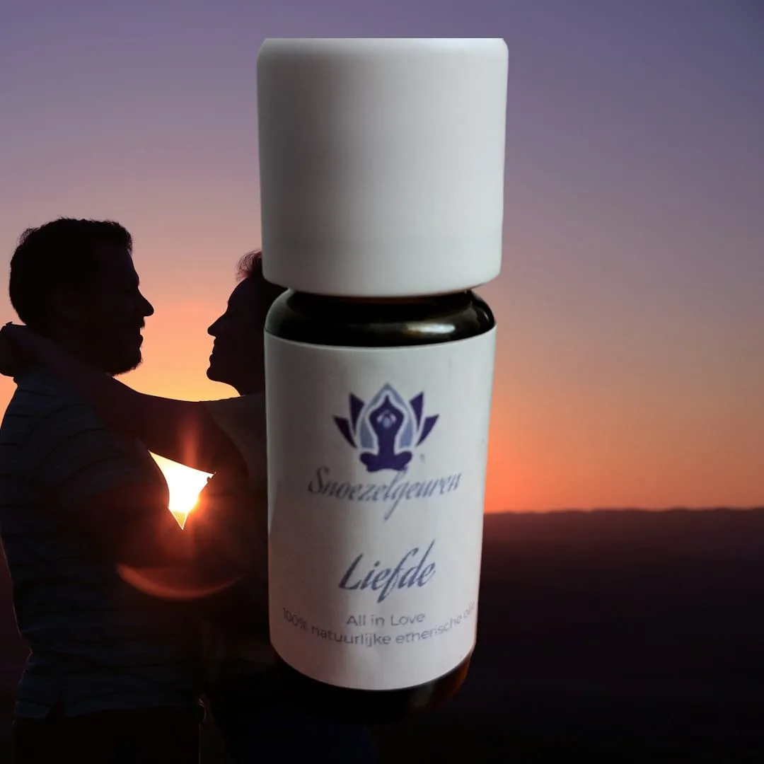 Een flesje etherische olie met op het etiket snoezelgeuren liefde met op de achtergrond een omarmend koppel bij zonsondergang.